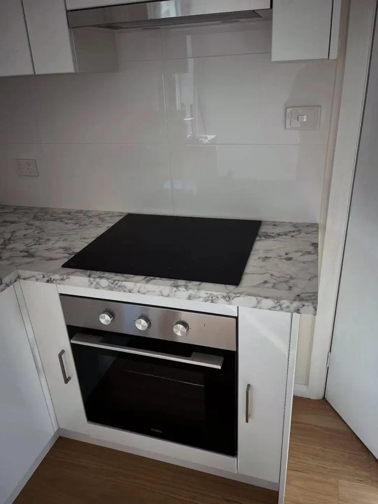 Modern electric cooktop and oven installation in residential kitchen